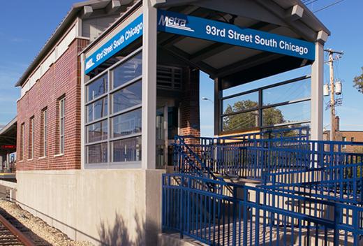 Station stop brick shelter with blue signage.