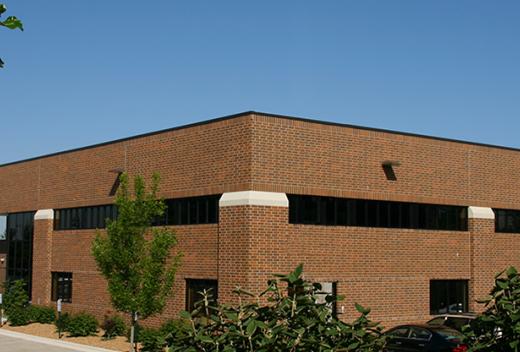 The exterior of a brown brick building with horizontal windows.
