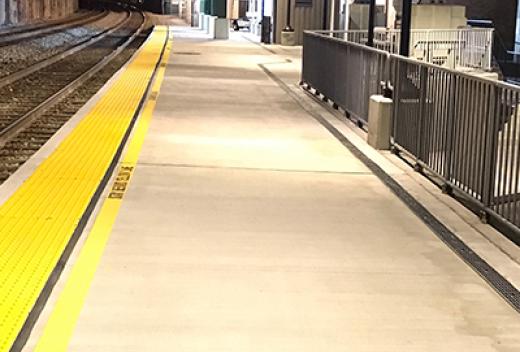 Concrete commuter platform with yellow safety strip.