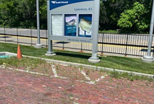 New station signage on a brick walkway