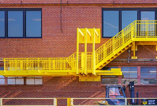 Safety ladder seen on exterior brick wall.