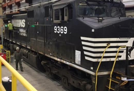 Norfolk Southern locomotive within maintenance building for repairs.