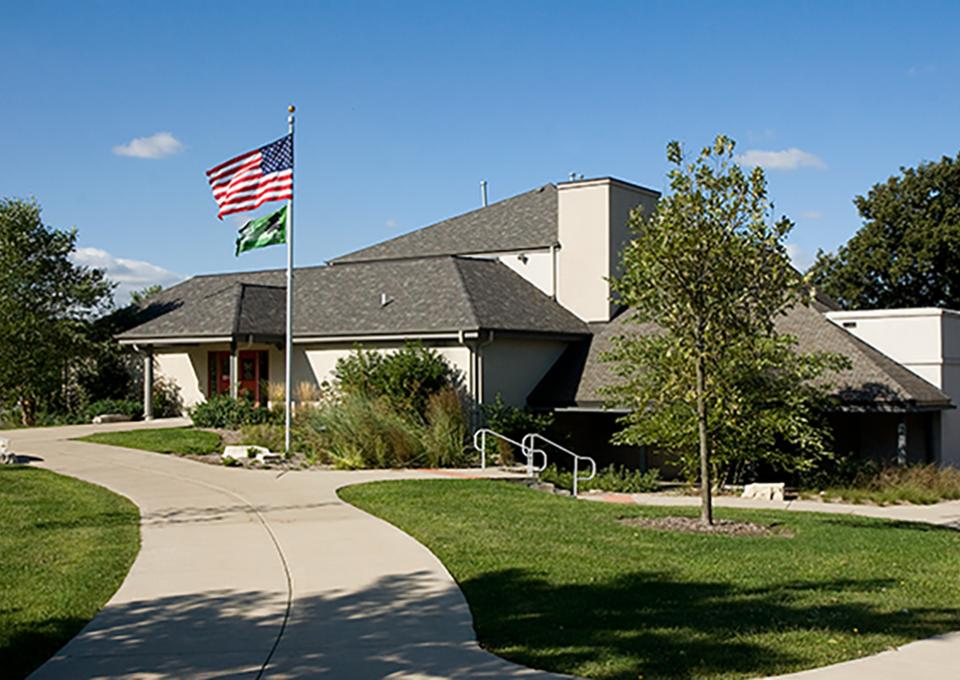 White brick building with a sizeable sloped roofline.