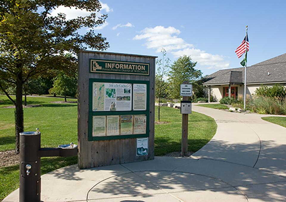 Exterior of building with wooden board with trail information.