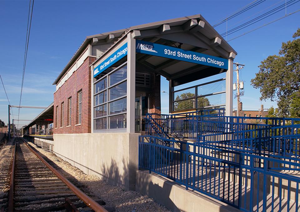 Station stop brick shelter with blue signage.