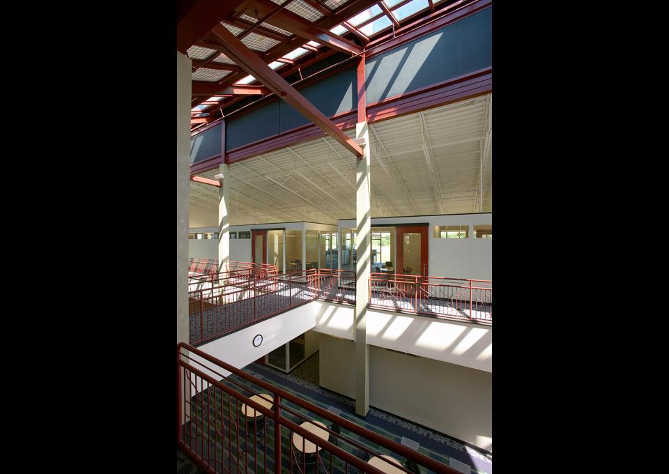 Interior second-story office space with structural steel ceiling and painted deep red and blue