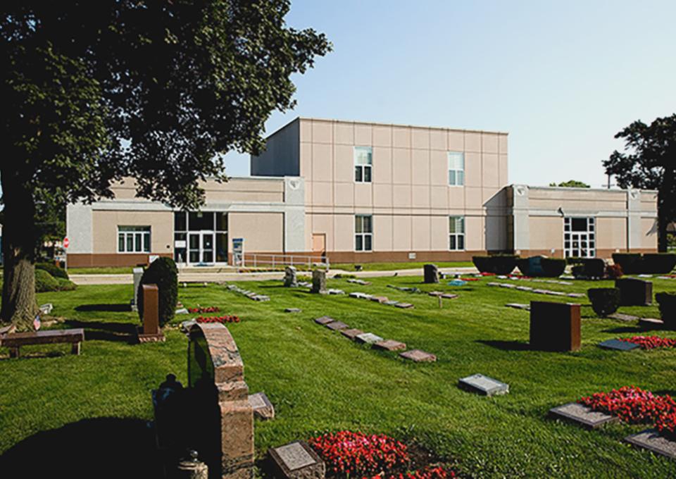 Precast concrete mausoleum with gravestones in the foreground.