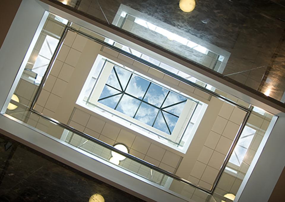 Skylight viewed from below with fluffy clouds and blue sky.