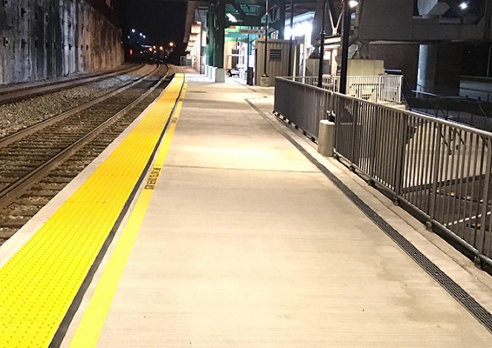 Concrete commuter platform with yellow safety strip.