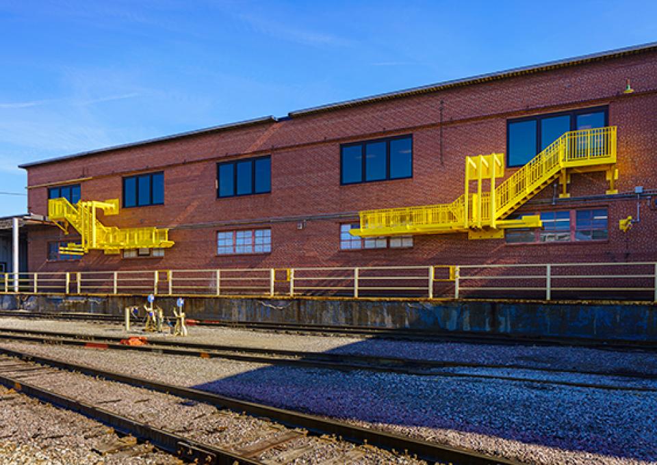 The total length of a brick building with two yellow safety ladders attached. 