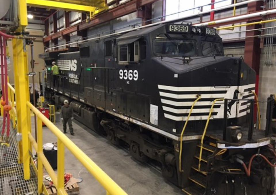 Norfolk Southern locomotive within maintenance building for repairs.