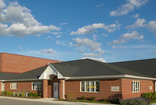 Red brick exterior of front of building with sunny blue sky