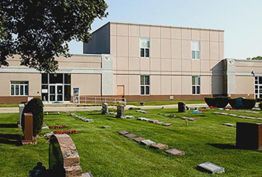 Precast concrete mausoleum with gravestones in the foreground.