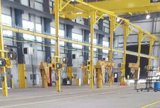 Interior of new car shop highlighting crane.