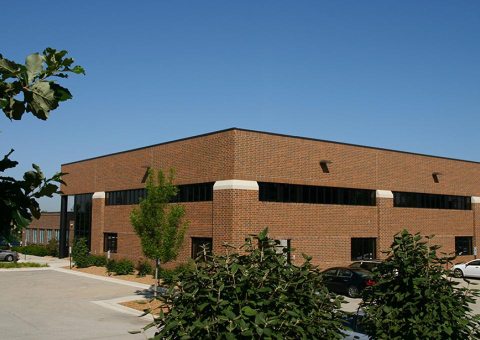 The exterior of a brown brick building with horizontal windows.