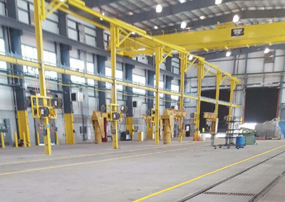 Interior of new car shop highlighting crane.